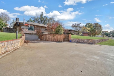 View of home's exterior featuring a yard, an attached garage, concrete driveway, and a chimney