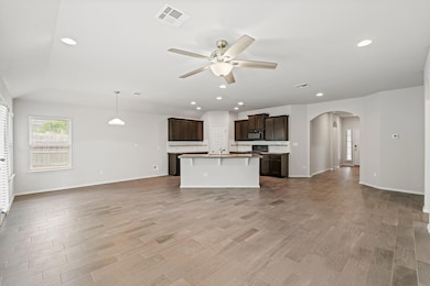 Unfurnished living room featuring a ceiling fan, 