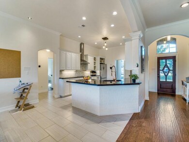 Kitchen with white cabinets, molding, sink, wall c