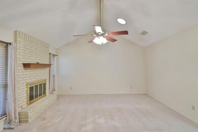 Unfurnished living room with light carpet, a brick