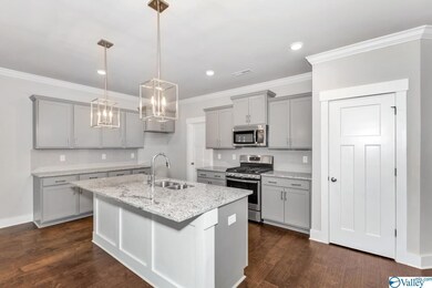 Similar picture; home has gourmet kitchen which includes, gas cooktop, furniture hood vent, wall microwave, wall oven, and trash bin drawer.