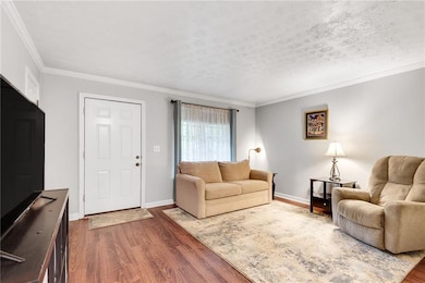 Living room featuring a textured ceiling, baseboar