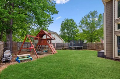 View of yard featuring a trampoline, a fenced back