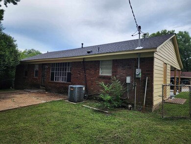 Back of house featuring a lawn and central air con