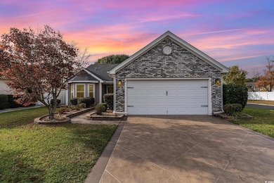 Ranch-style home featuring a garage and a yard