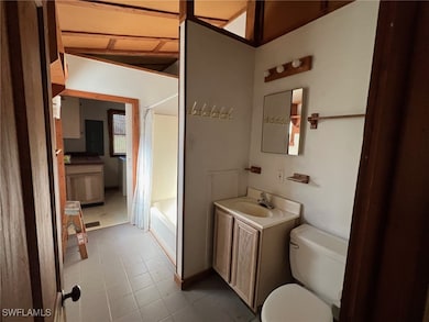 Full bathroom with vanity, vaulted ceiling, tile p