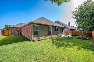 Rear view of house with central air condition unit, a lawn, and a patio area