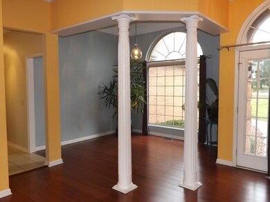 Formal dining room with bamboo floor & beautiful arched window.