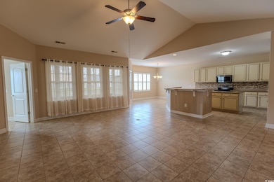 Unfurnished living room with vaulted ceiling, light tile patterned floors, ceiling fan, a chandelier, and baseboards