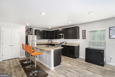 Spacious Kitchen With Stainless Steel Appliances, Granite Counters, & A Central Island Breakfast Bar