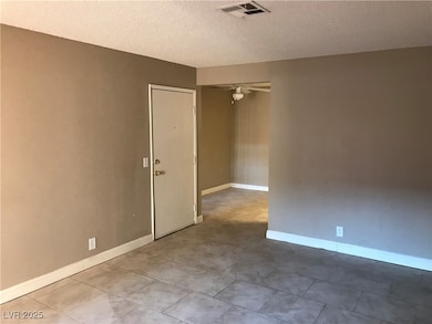 Empty room featuring ceiling fan, a textured ceili
