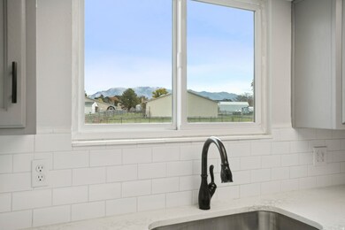 Kitchen view of tasteful backsplash and light stone counters