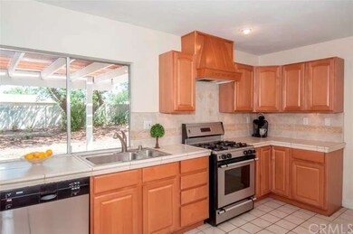 Kitchen features stainless appliances, tile counte