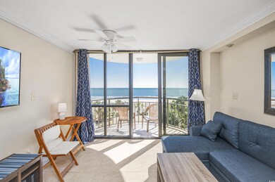 Living area with a wall of windows, tile patterned flooring, view of water and beach, a ceiling fan, and crown molding