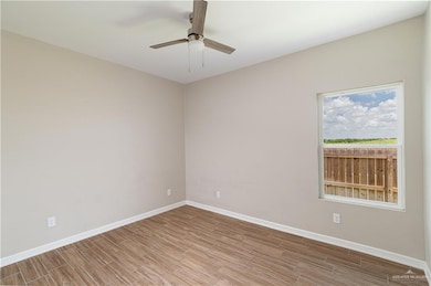 Empty room with light wood-style floors and a ceiling fan