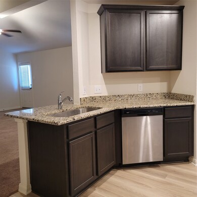 Beatutiful granite counter tops, stainless dishwasher and the barn sink