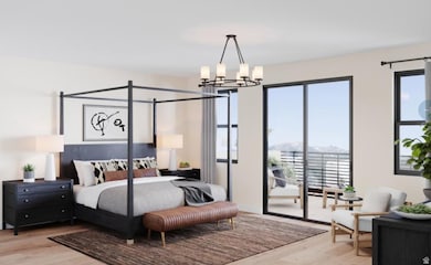 Primary bedroom featuring a spacious balcony, multiple windows, and beautiful LVP flooring.