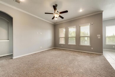 Carpeted spare room with ornamental molding and ceiling fan