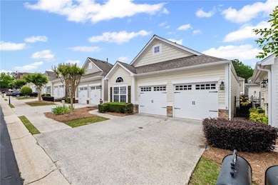 Craftsman inspired home with concrete driveway, stone siding, roof with shingles, and an attached garage