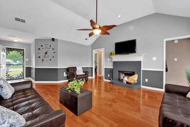 Living area with a brick fireplace, visible vents,