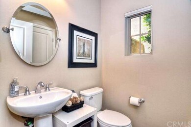 Powder room with pedestal sink and polished chrome