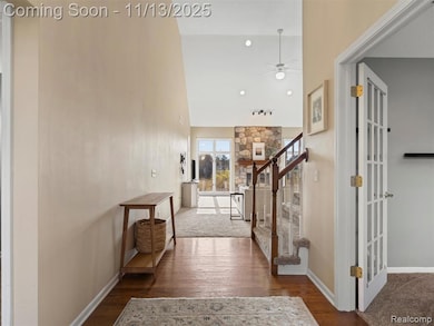 Hall with dark wood-style floors, high vaulted ceiling, stairs, and recessed lighting
