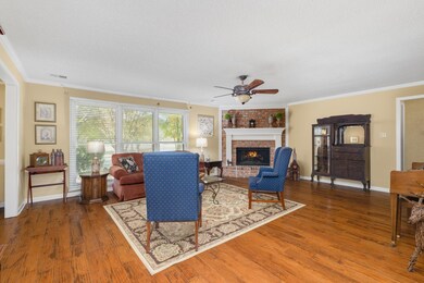 Living room with a textured ceiling, a brick firep
