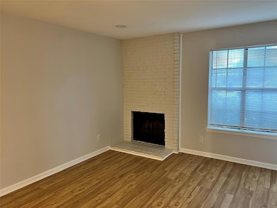 Unfurnished living room with baseboards, wood fini