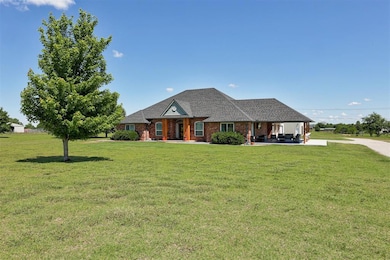 View of front facade featuring a front yard, roof with shingles, and brick siding