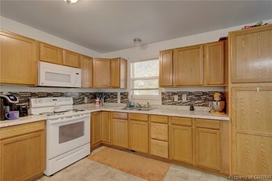 Kitchen featuring light tile floors, sink, white a