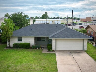 View of front of home with a shingled roof, brick 