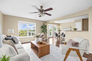 Living area featuring a chandelier, a ceiling fan, and wood finished floors