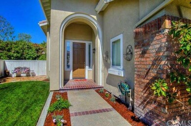 Brick-accented walkway and arched portico welcome 