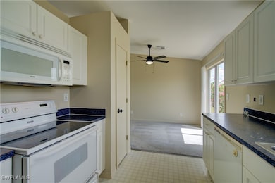 Kitchen featuring white appliances, a ceiling fan,