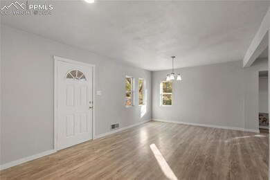 Foyer entrance with a chandelier and light hardwoo