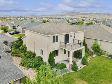 Back of house with a patio area, a residential view, stucco siding, roof with shingles, and a lawn