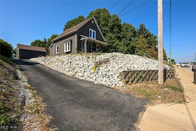 View of side of home featuring an outdoor structure and a porch