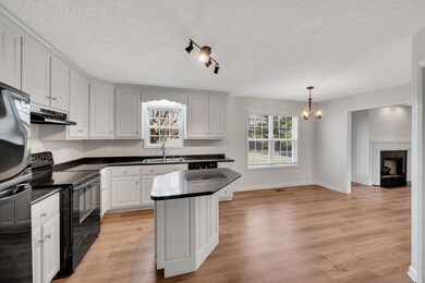Open floorplan with dining area in kitchen that opens to the Great Room with fireplace.
