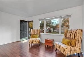 Living area featuring dark wood-type flooring and baseboards