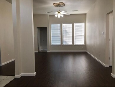 Empty room featuring ceiling fan and dark hardwood / wood-style flooring