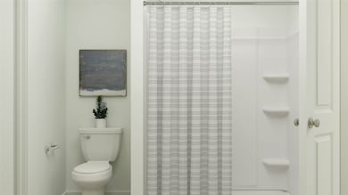 Full bathroom featuring a shower with shower curtain and toilet