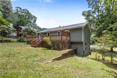 Rear view of house featuring stairs and a wooden deck