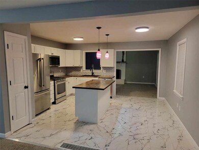 Beautiful new kitchen with ceramic tile floors, pantry, butcher block counters and island.