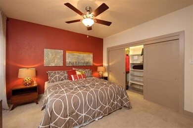 Bedroom featuring a closet, light carpet, and a ceiling fan