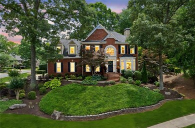 Colonial home with brick siding, a chimney, and a front lawn