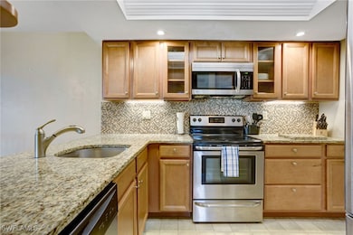 Kitchen featuring tasteful backsplash, sink, a tra