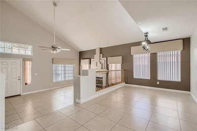 Empty room featuring high vaulted ceiling, visible