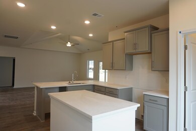 Kitchen featuring a center island, sink, vaulted c