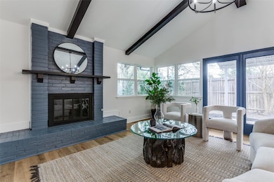 Living area with beamed ceiling, a fireplace, wood