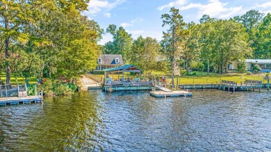 View of dock with a water view and a lawn